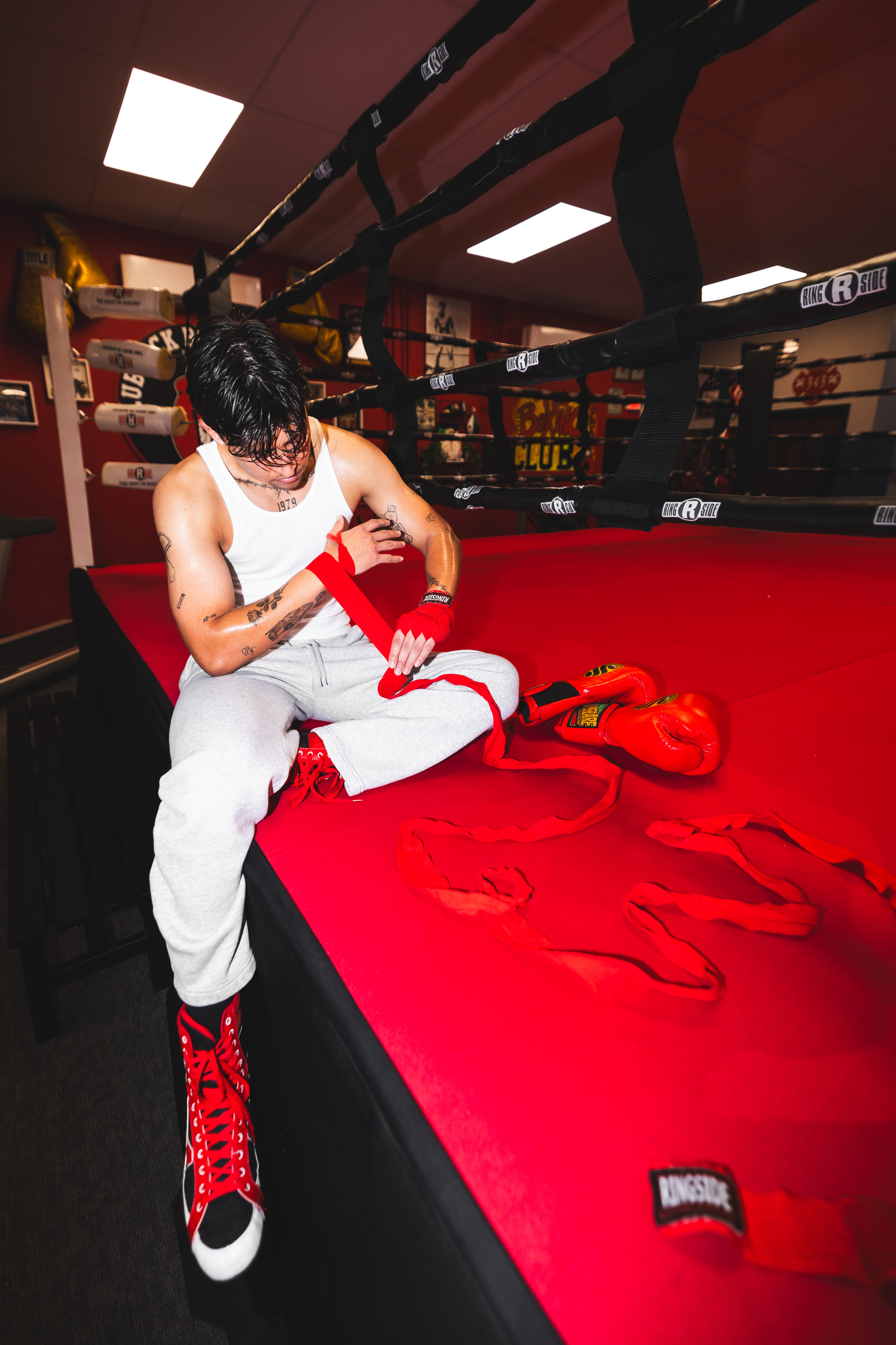 Alex Films wrapping hands in a boxing gym before a shoot.